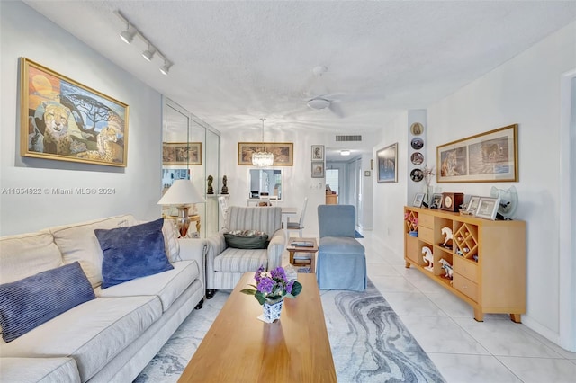 living room featuring a textured ceiling, rail lighting, light tile patterned flooring, and ceiling fan