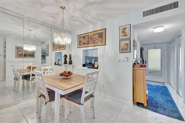 dining room featuring light tile patterned floors, a textured ceiling, and an inviting chandelier