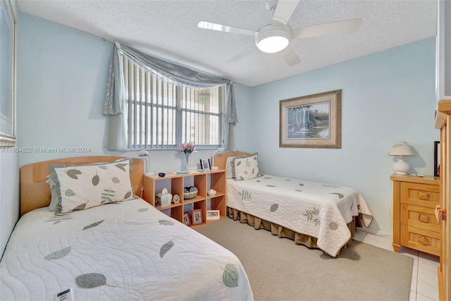 tiled bedroom with a textured ceiling and ceiling fan