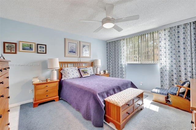 bedroom with light carpet, a textured ceiling, and ceiling fan