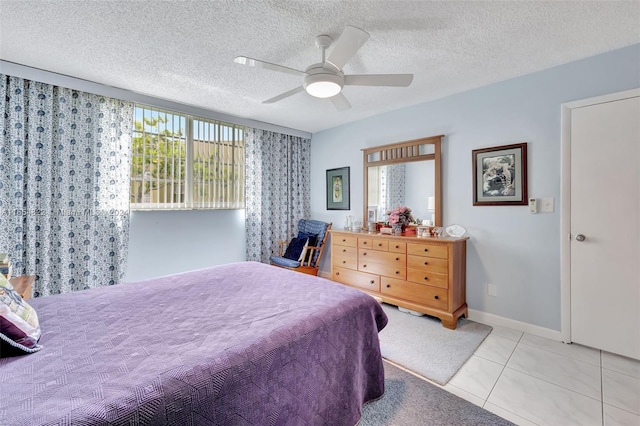 tiled bedroom featuring a textured ceiling and ceiling fan