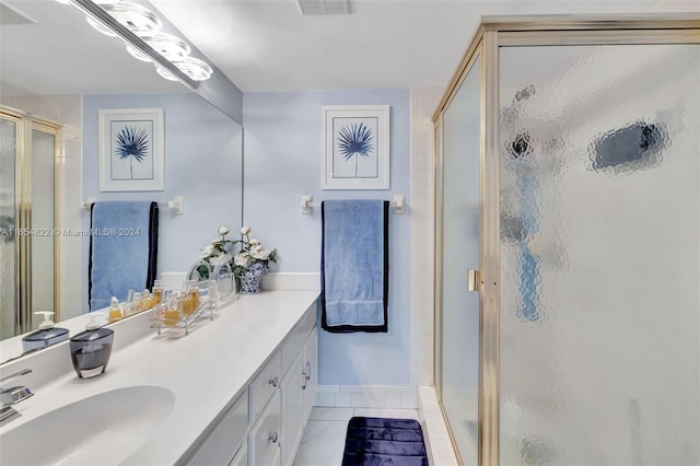 bathroom with tile patterned flooring, vanity, and an enclosed shower