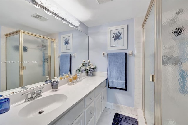 bathroom featuring vanity, a shower with shower door, and tile patterned flooring