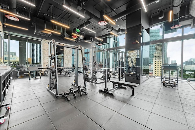 workout area with a view of city and expansive windows