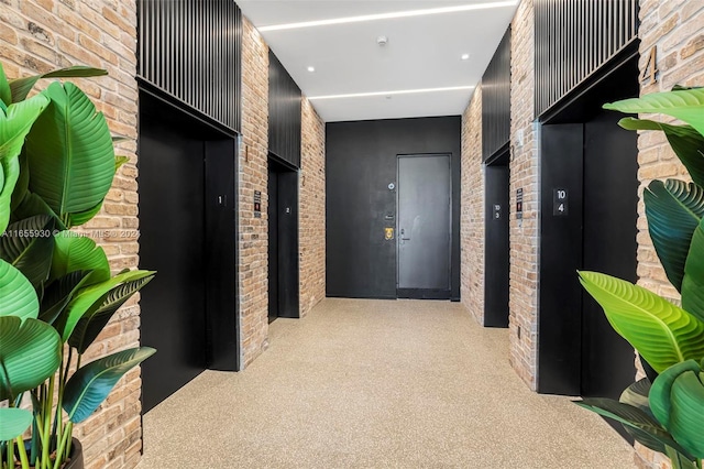 hall with elevator and brick wall