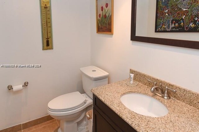 bathroom featuring tile patterned flooring, toilet, and vanity