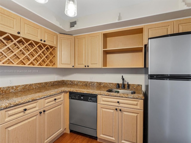 kitchen featuring light stone counters, sink, stainless steel appliances, and light brown cabinets