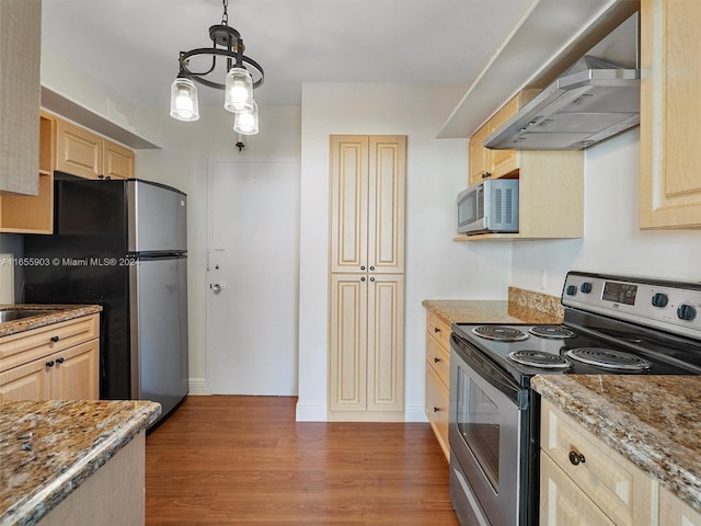 kitchen with an inviting chandelier, stainless steel appliances, dark hardwood / wood-style flooring, wall chimney exhaust hood, and pendant lighting