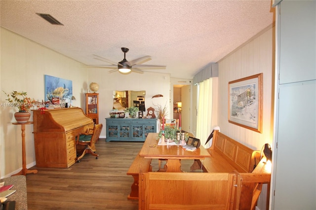 living room with ceiling fan, a textured ceiling, and hardwood / wood-style floors