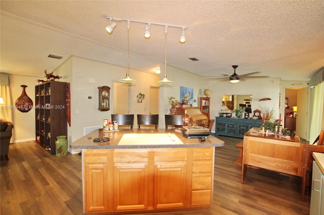 kitchen with a textured ceiling, dark wood-type flooring, pendant lighting, and ceiling fan