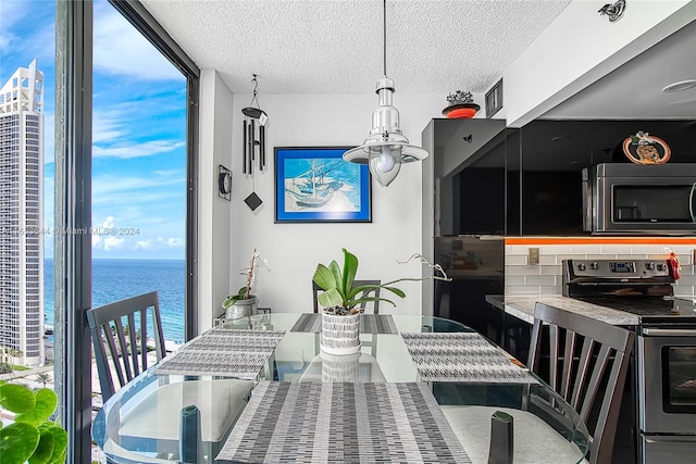 dining room featuring a textured ceiling and a water view