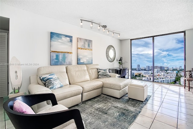 tiled living room featuring a textured ceiling, a wealth of natural light, and floor to ceiling windows