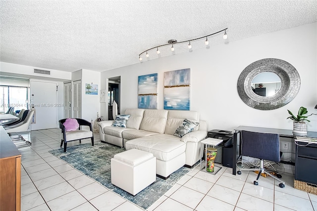 living room featuring a textured ceiling and light tile patterned floors