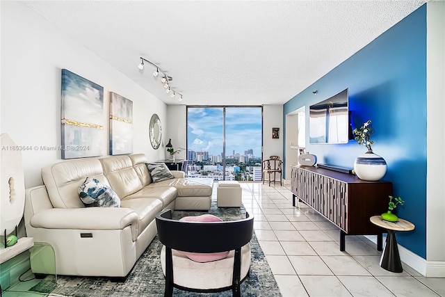 living room with floor to ceiling windows, a wealth of natural light, light tile patterned flooring, and a textured ceiling