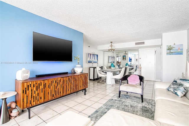 living room featuring light tile patterned floors, a notable chandelier, and a textured ceiling