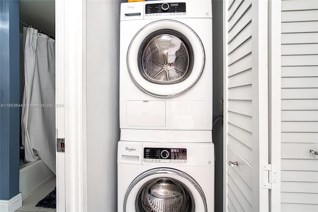 laundry room featuring tile patterned floors and stacked washer / drying machine