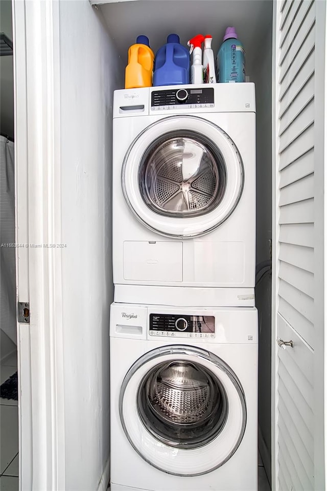 clothes washing area with stacked washing maching and dryer