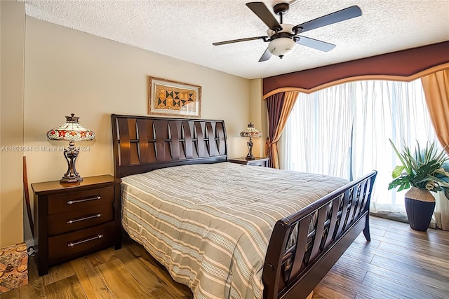 bedroom with a textured ceiling, hardwood / wood-style floors, and ceiling fan