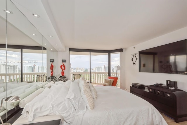 bedroom with access to outside, light hardwood / wood-style floors, and floor to ceiling windows