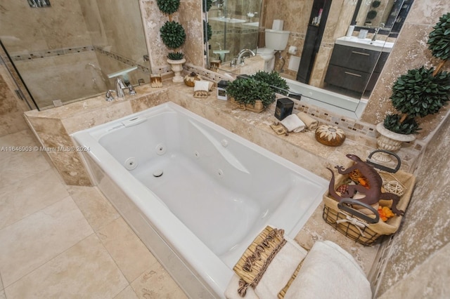 bathroom with a relaxing tiled tub, tile patterned flooring, and vanity