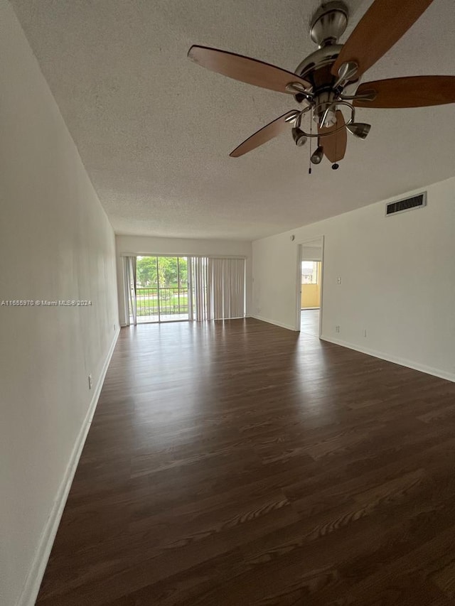 unfurnished room featuring a textured ceiling and dark hardwood / wood-style floors