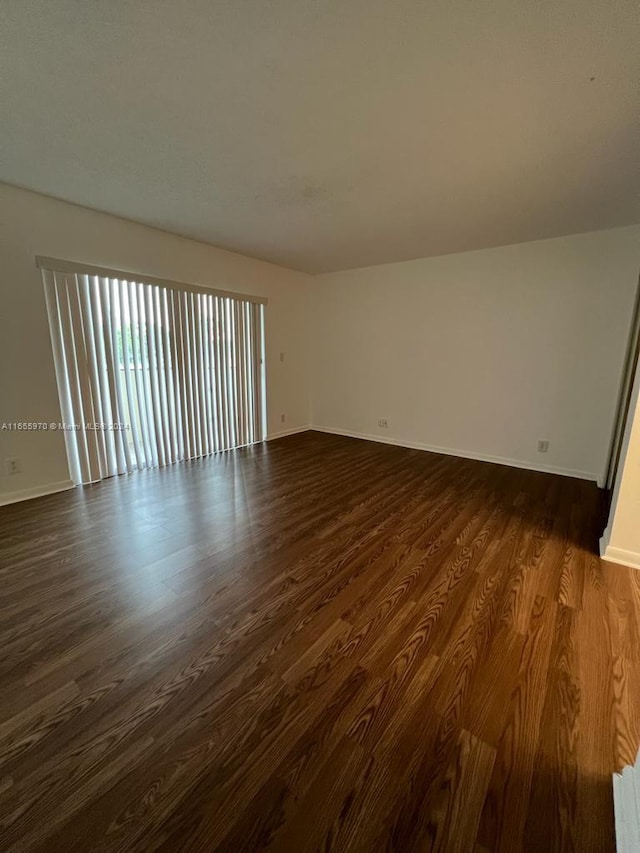 unfurnished room with dark hardwood / wood-style floors