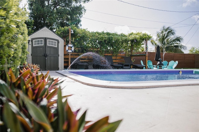 view of swimming pool with pool water feature, a shed, and a patio area