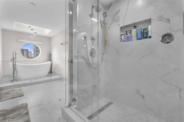 bathroom featuring a skylight and separate shower and tub