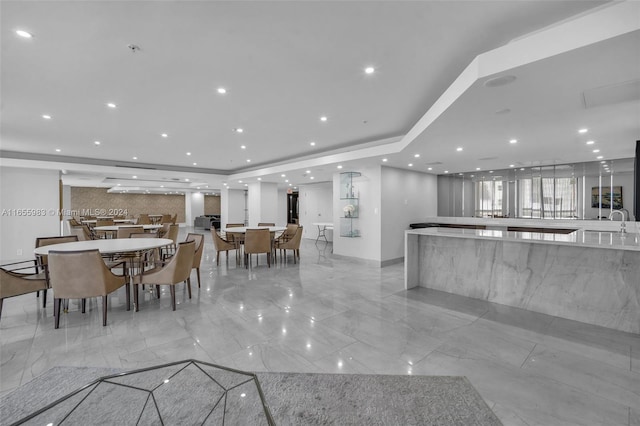 kitchen with a spacious island, sink, and white cabinetry