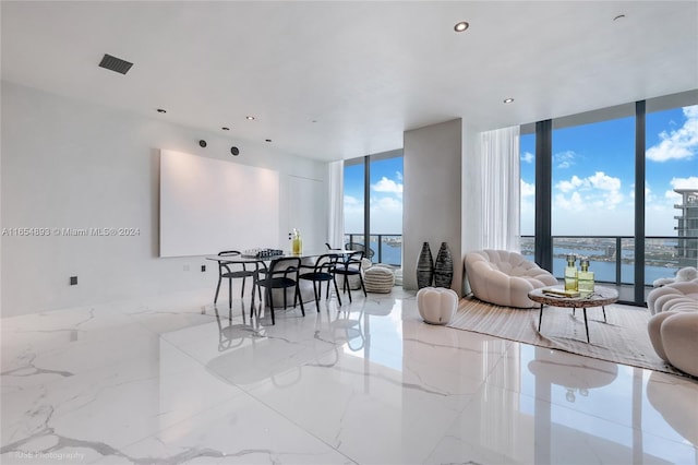 dining space featuring a water view and a wall of windows