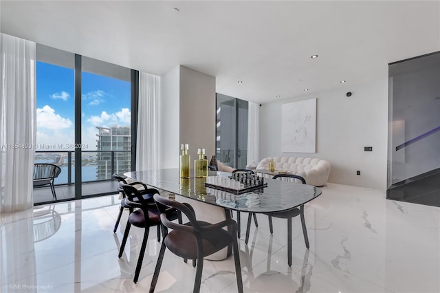 dining area featuring a water view and a wall of windows