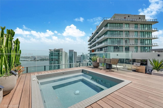 view of pool with a water view and an outdoor hot tub