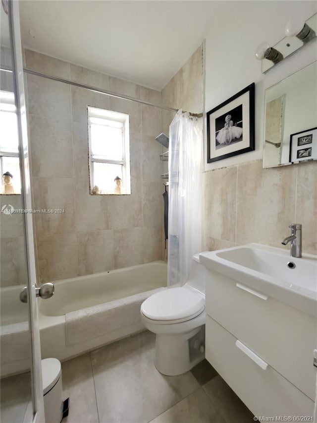 full bathroom featuring vanity, shower / bath combination with curtain, tile walls, toilet, and tile patterned floors