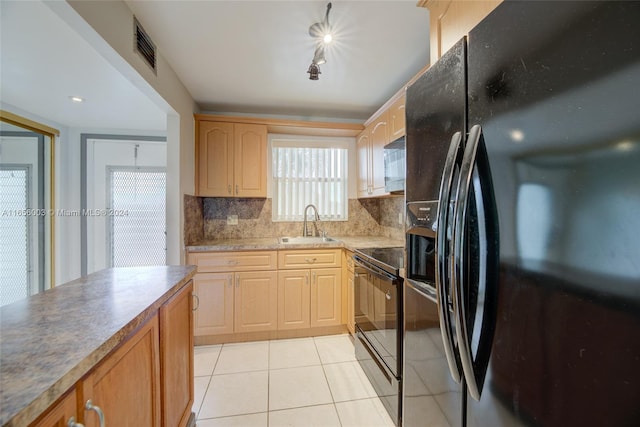 kitchen featuring light tile patterned floors, sink, backsplash, black appliances, and light brown cabinetry