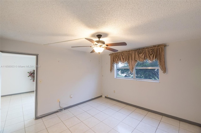 empty room with ceiling fan and a textured ceiling