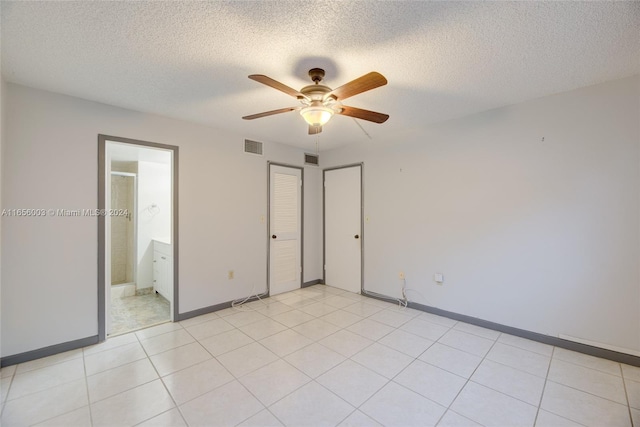 unfurnished bedroom with a closet, ensuite bath, a textured ceiling, and ceiling fan