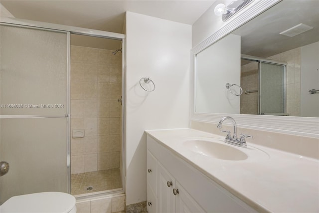 bathroom with vanity, a shower with shower door, and toilet