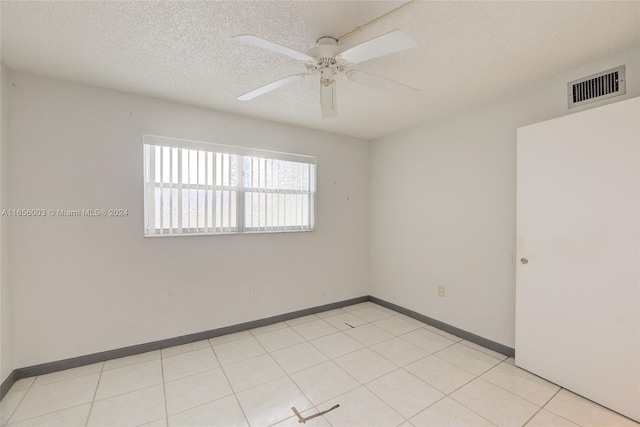 tiled spare room with ceiling fan and a textured ceiling