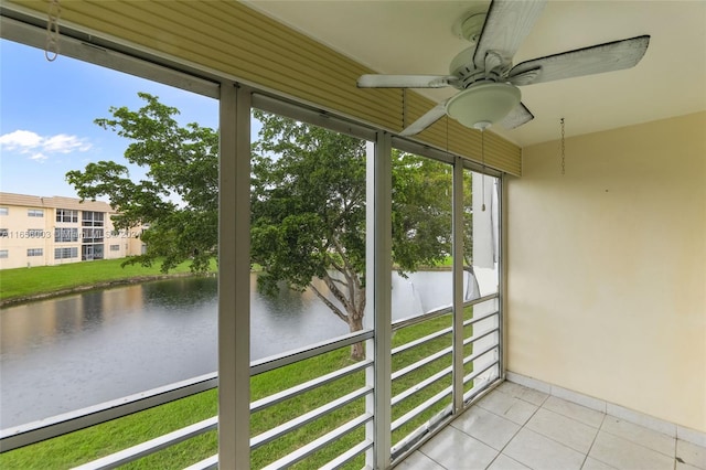 unfurnished sunroom featuring ceiling fan and a water view