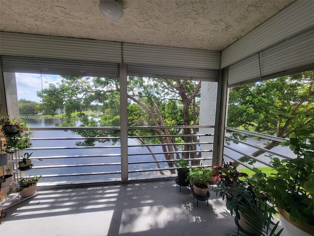 unfurnished sunroom featuring a water view