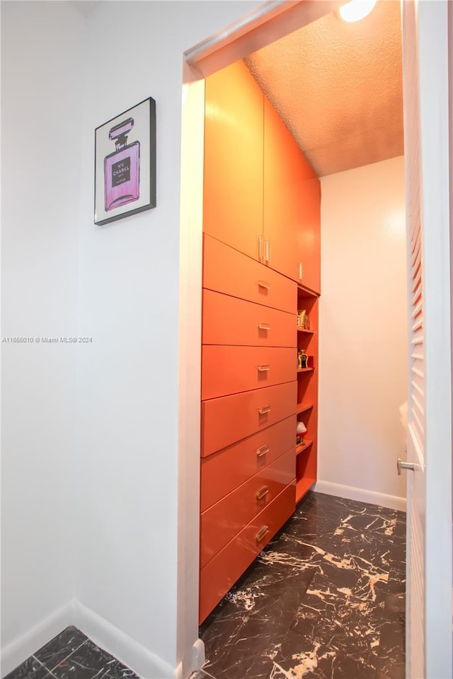 hallway featuring a textured ceiling and vaulted ceiling