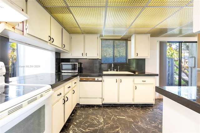 kitchen featuring white appliances, tasteful backsplash, and sink