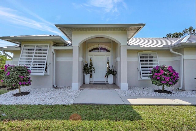 view of exterior entry with a yard