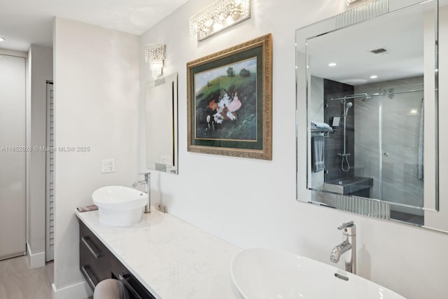 bathroom featuring vanity and a shower with shower door