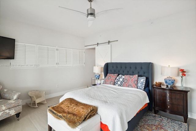 bedroom with a barn door and ceiling fan