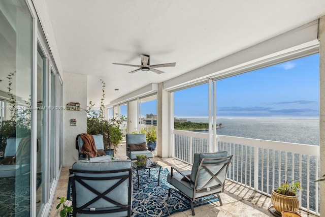 sunroom / solarium with a water view and ceiling fan