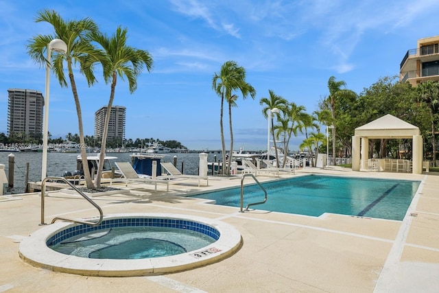 view of pool with a gazebo, a patio area, a hot tub, and a water view