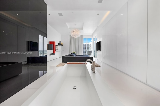 bathroom featuring a raised ceiling and a chandelier