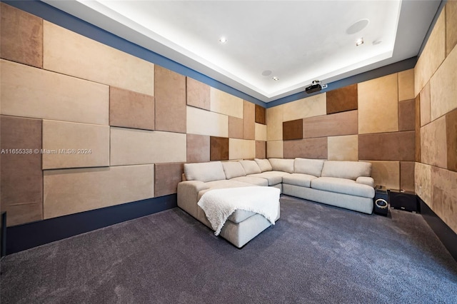 cinema room with tile walls, carpet floors, and a tray ceiling