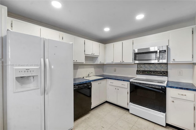 kitchen with white cabinets, light tile patterned flooring, white appliances, and sink